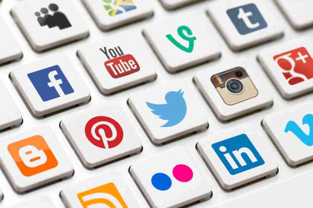 What is Social Media Marketing for Business? Modern white keyboard with colored social network buttons.